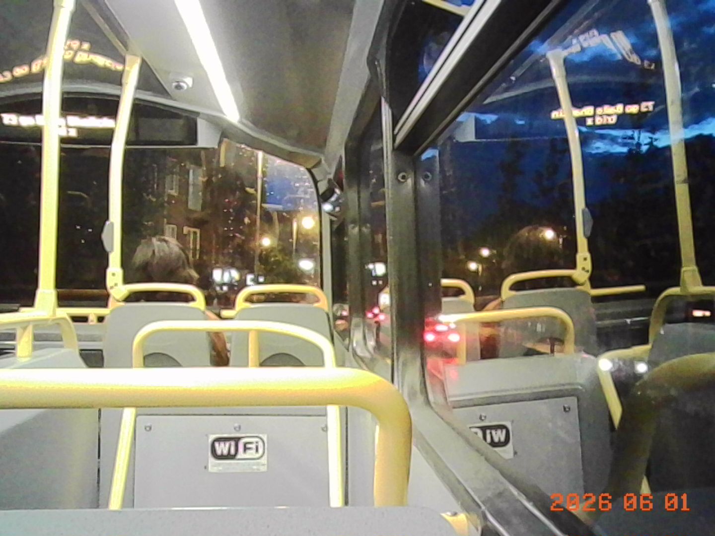 A low resolution photo taken on the upper deck of a Dublin bus at night time.